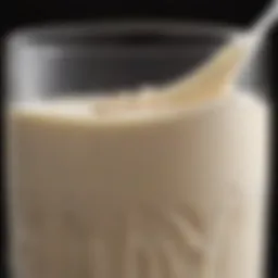 A close-up view of oat milk in a glass, highlighting its creamy texture and color.