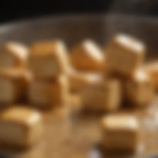 A close-up of golden brown marshmallows melting in a saucepan.