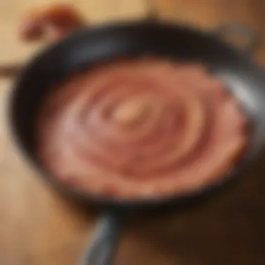 Bacon Fat Rendering in Skillet A close-up of bacon fat rendering in a skillet