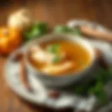 A warm bowl of chicken broth surrounded by fresh herbs and spices